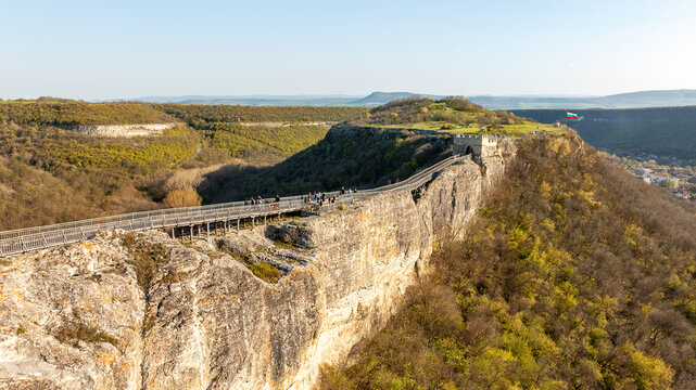 Aerial exploration of Ovech Fortress in Bulgaria during spring time. Detailed view of the wooden bridge walkway on high vertical cliffs near Provadia. History and scenic nature combination.