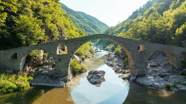 Devils Bridge Bulgaria aerial drone view Rhodope range summer. Scenic ottoman stone bridge Arda river canyon forest landscape. Historic nature landmark Balkan mountains travel destination scenery view