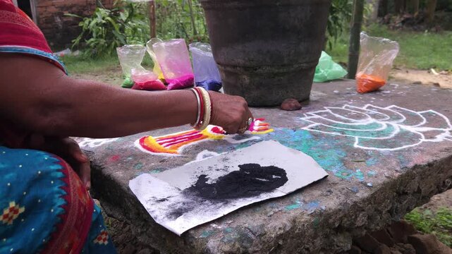 Making rangoli design using colored powders by woman hand, traditional Indian folk art on floor with mandala patterns, vibrant cultural decoration for festivals like Diwali, representing creativity