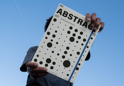 Real photo of faceless man Holding a Blank front cover Book Against the Sky. PSD mockup.