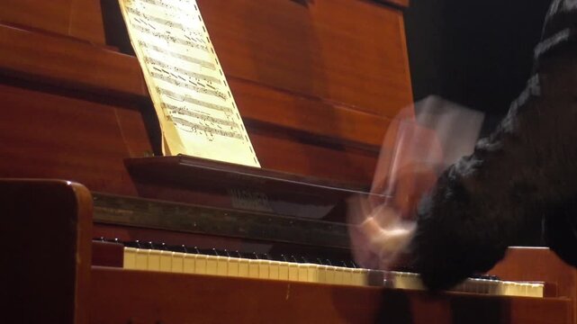 A close-up of a woman's hands moving expressively across the keys of a piano.