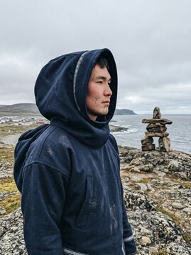 Young Inuit Man with Traditional Face Tattoos Looking at Arctic Horizon