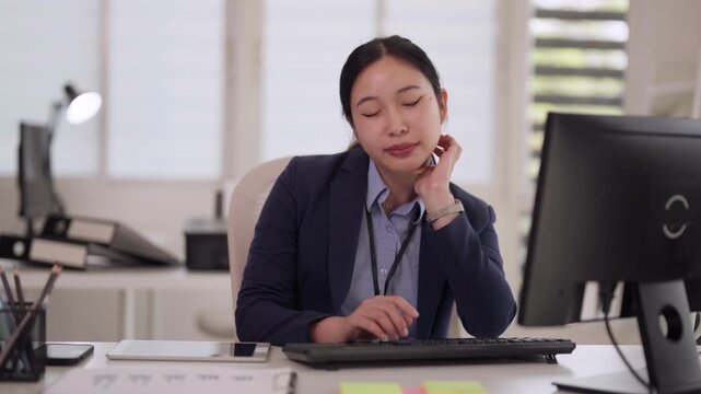 Asian adult professional woman voice command smartphone office desk technology communication smiling productive workplace
