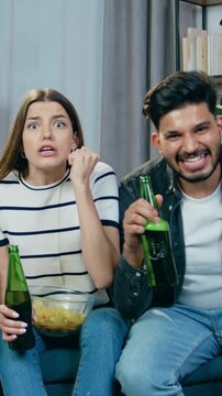 People emotions concept where attractive agitated 30s african americn guy and muslim girl in hijab previsioning football match online on computer and enjoying scored goal screaming and giving high