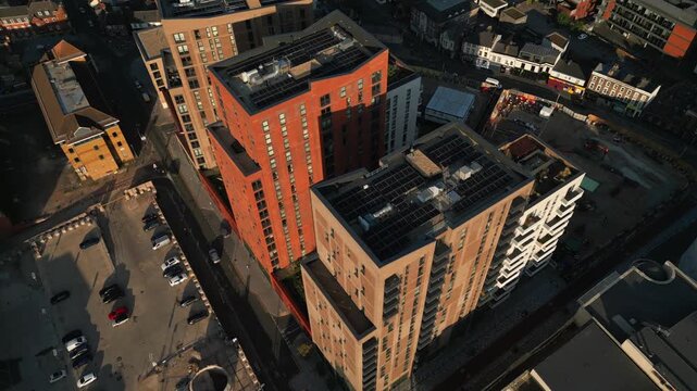 Aerial view of modern buildings with solar panels on roofs in an urban setting.