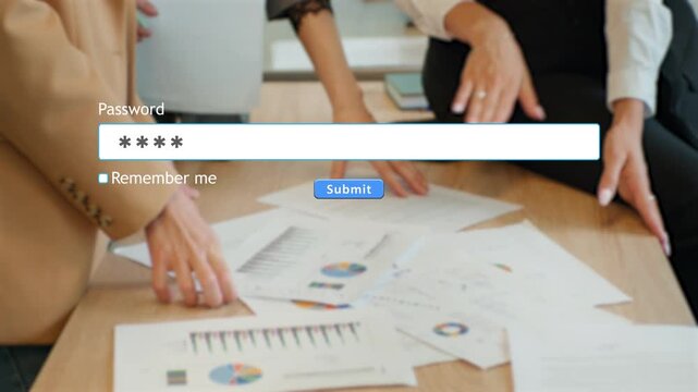 A user types a password into a website form box on a computer. Papers and employees' hands can be seen in the background at an office desk.