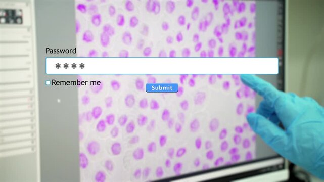 A person types their password into a website form box while in an in vitro laboratory. The background shows a microscopic image of cells on the computer screen.