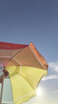 Un paraguas colorido con un cielo despejado y el oc&eacute;ano Pac&iacute;fico al fondo