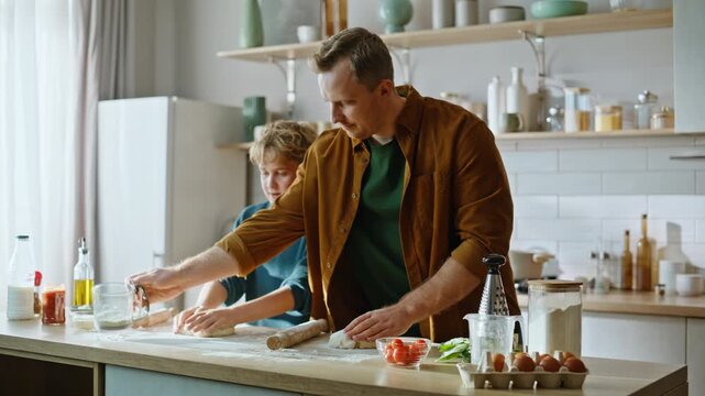 Father teaching son cooking homemade bread standing modern kitchen closeup. 
