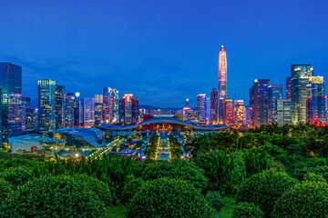 Obraz premium Blue hour skyline of Shenzhen civic center with illuminated skyscrapers and urban greenery in Futian district, China.