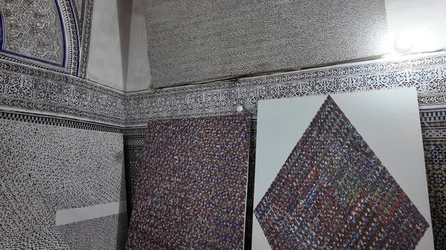 Contemporary mosaic art exhibition in traditional Moroccan riad showing intricate geometric patterns and hand painted canvases