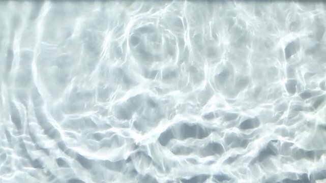 Abstract close-up of clear water under bright sunlight, where gentle ripple patterns shift continuously from frame to frame, forming a clean shimmering texture for a calm background.