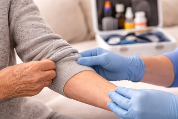 Obraz premium Healthcare Worker Checking Elderly Patient Arm During Medical Examination