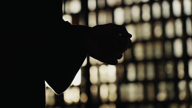 Silhouetted muslim person praying with tasbih beads