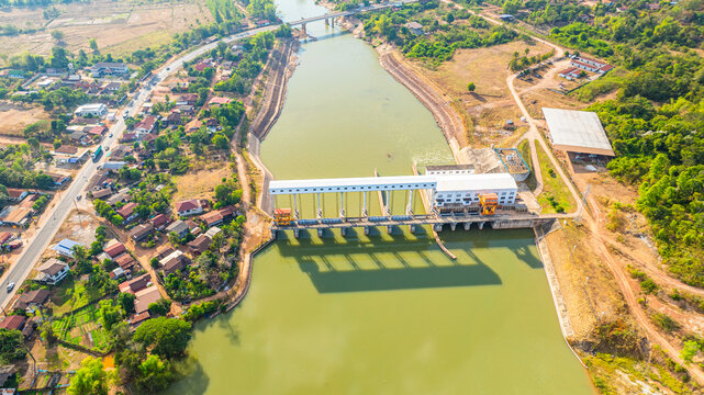 aerial view of the Nam Hinboun River dam in Laos, showcasing hydropower infrastructure surrounded by lush green countryside. This high-angle drone image highlights renewable energy production