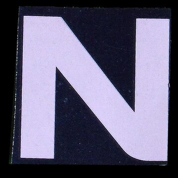 A stark white uppercase letter N displayed prominently on a solid black square background, creating a high-contrast graphic element.