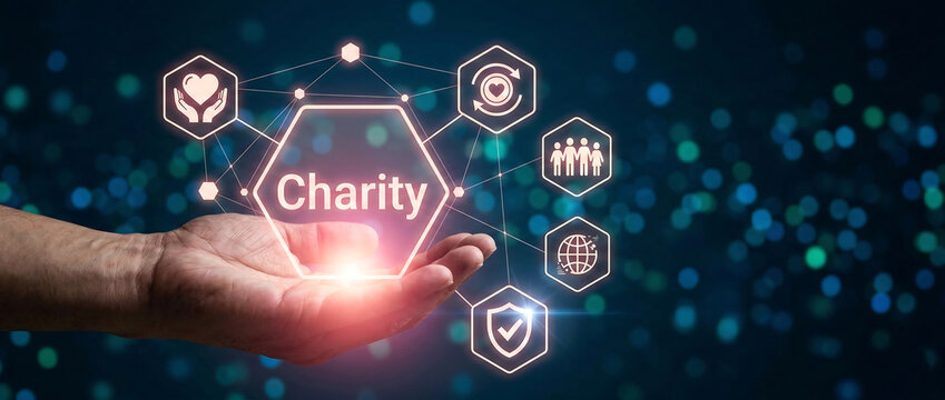 Hand holding glowing charity icon with digital donation symbols on futuristic blue background for fundraising and social impact