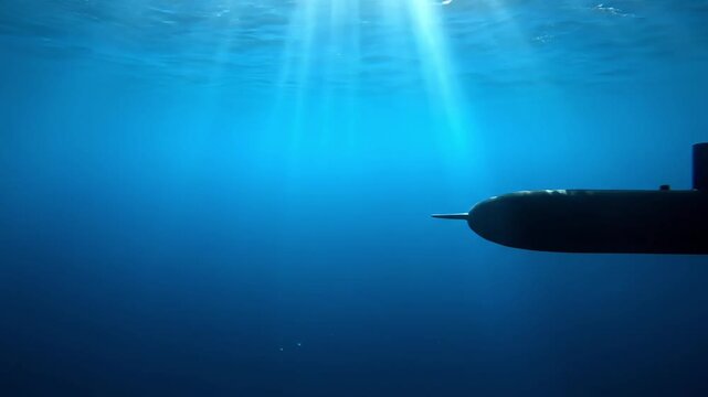 silhouette of submarine underwater with sunbeams shining through ocean water
