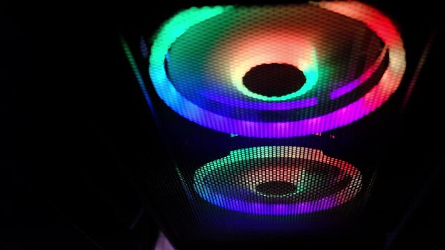 Dark tech scene shows RGB fans glowing in a desktop case, bright colors framed by black space for a minimal composition. Gaming setups boost creativity and community, but screen time balance matters.