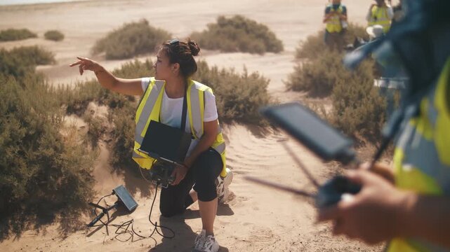 A man in the desert on the set of a film controls a quadcopter