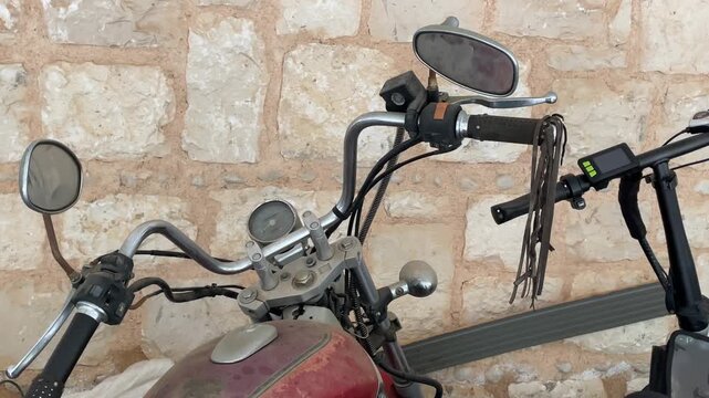 Vintage motorcycle handlebars with mirrors against textured stone wall background