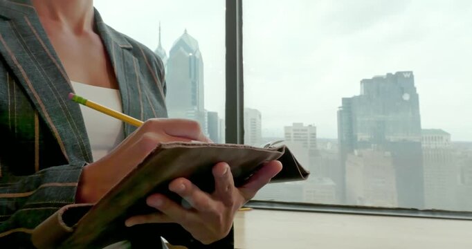 Businesswoman Writing Notes in Modern Office with Cityscape View