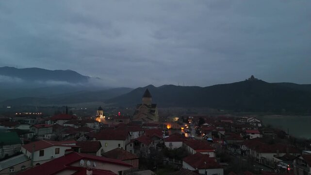 Scenic aerial view of mtskheta town at twilight with svetitskhoveli cathedral and jvari monastery illuminated, capturing the historic landscape of georgia