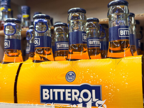 Villach, Austria - March 19, 2026: Bottles of Bitterol beer displayed in a cardboard packaging with vibrant orange label and blue branding in a retail setting