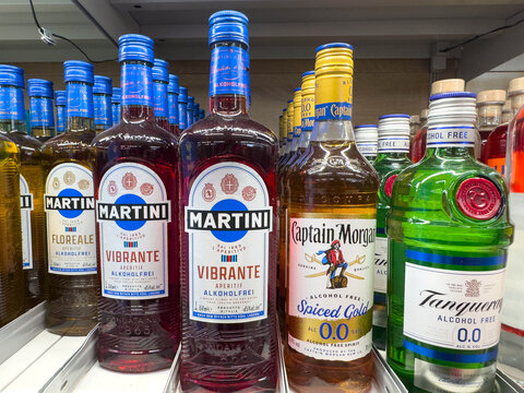 Villach, Austria - March 19, 2026: Bottles of non-alcoholic beverages including Martini Vibrante, Captain Morgan Spiced Gold, and Tanqueray displayed on a supermarket shelf
