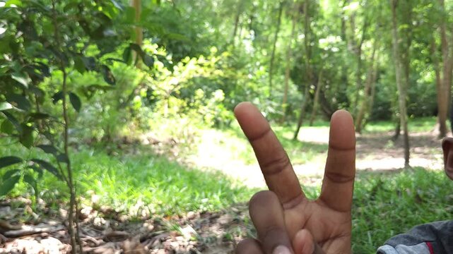 Human hand showing three fingers gesture outdoors in natural environment, close up of hand sign representing number three, counting, symbol, communication and body language concept in India