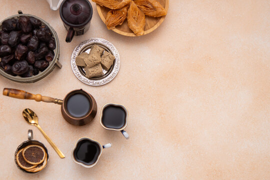Oriental sweets and coffee cups on the table during Ramadan. Baklava and dates top view. Sweet food background copy space.