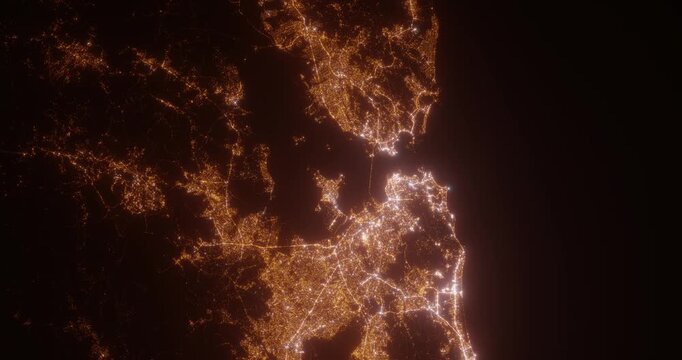 Rio De Janeiro (Brazil) top view at night. Aerial view on modern city with lights. Camera is flying above the city, moving backward. Vertical video. The north is on the left side