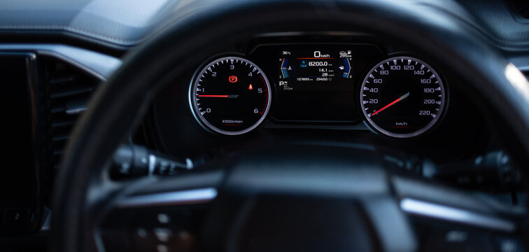 Modern Car Digital Dashboard and Instrument Cluster in Close-up,A high-angle, close-up shot of a modern vehicle's dashboard and steering wheel, displaying a digital speedometer, tachometer, fuel gauge