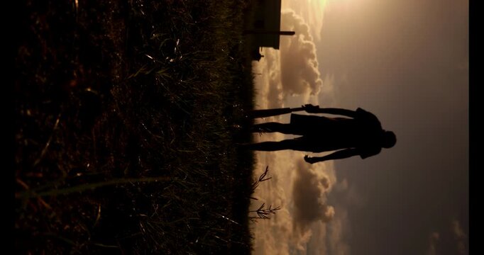 Cricket players silhouette practicing with bat under dramatic cloudy sky at sunset, outdoor sports scene with strong contrast and horizon, representing passion, training and Indian cricket culture
