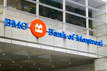 Naklejka premium Toronto, Canada - February 15, 2026: Bank of Montreal headquarters building with corporate logo and flags in Toronto downtown financial district