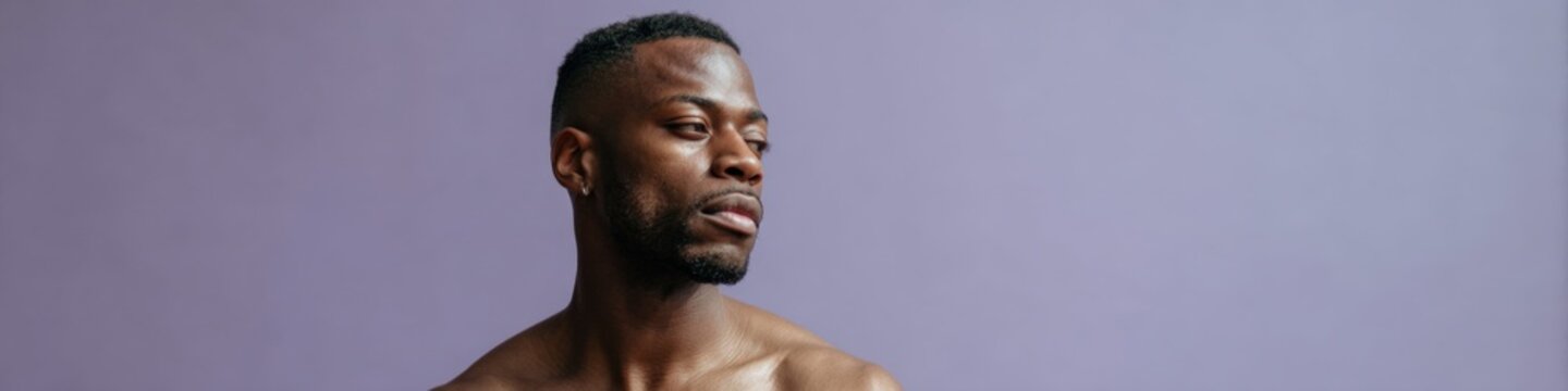 African male adult torso strong athletic barechest against soft purple backdrop dramatic side gaze conveying strength and poise for fitness concepts