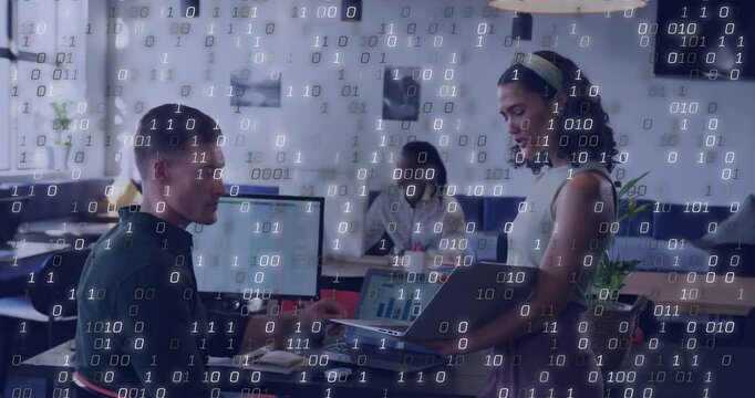 Standing woman with laptop leading sales rep leaning and reviewing charts and binary overlay rising