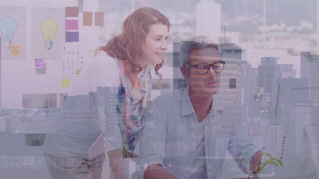 Vertical video: Leaning woman pointing at screen in scarf at desk man using mouse reviewing design