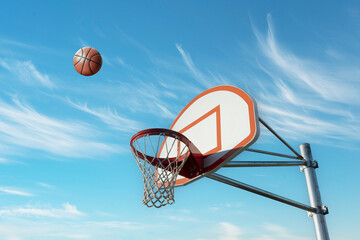 Basketball Approaching Hoop Against A Blue Sky © Rix Pix