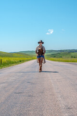 Obraz premium Lone figure walks down a wide, open road