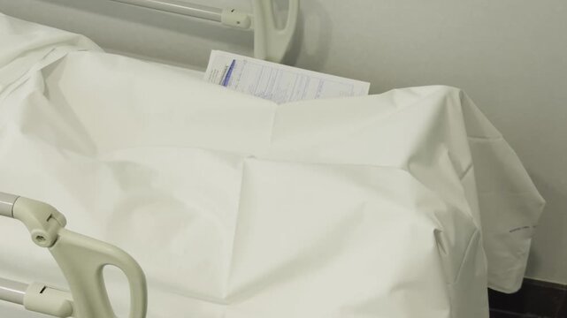 A dead body covered with a white sheet lying on a gurney in a hospital. Doctors fought for the patient's life. High quality 4k footage