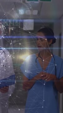 Vertical video: Dr checking chart urging nurse walking medical ward talking care overlaying nodes