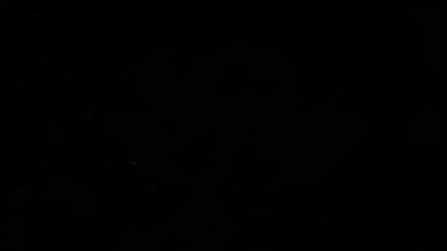Dust particles floating in dark space with subtle glow effect