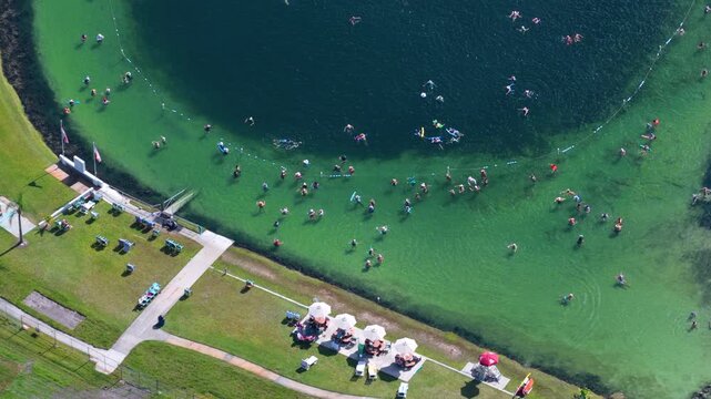 Natural thermal spring sinkhole used as public swimming area. Relaxation and alternative wellness therapy in serene tropical setting.
