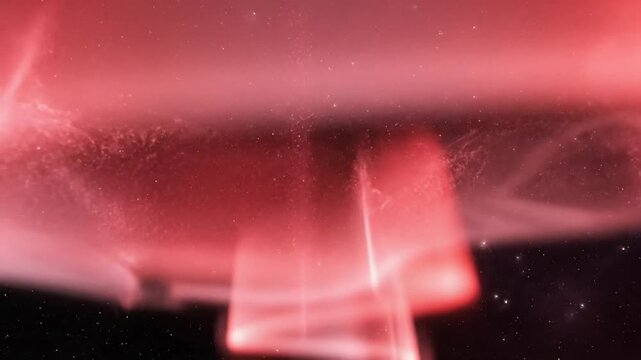Mesmerizing aerial red aurora borealis light display of space particles against a starry night