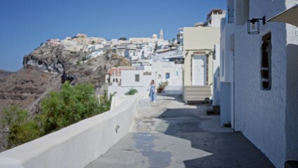 Fototapeta premium Whitewashed mediterranean alley with sunlit blue sky, soft bokeh and defocused village backdrop outdoor; background copyspace calm.