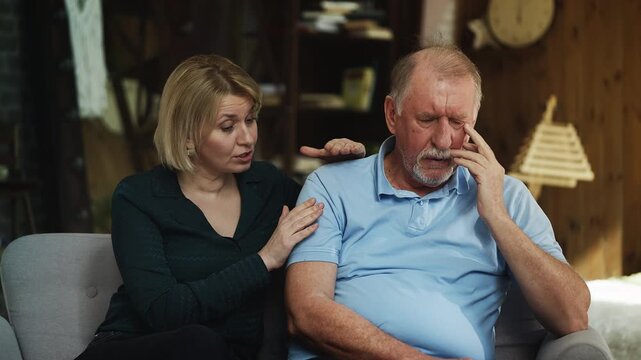 Middle-aged woman comforting her unhappy senior father, taking care of parent