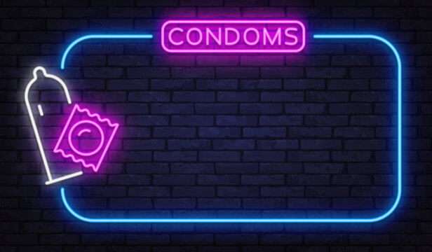 Neon sign with condom icon and bright lettering on dark brick wall. Vibrant pink and blue glow creates bold night shop atmosphere. Ideal for pharmacy ads, adult store banners, or safe sex campaigns
