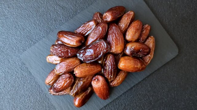 Dried dates on a ceramic plate for Ramadan or Iftar. Dried dates as a food background for your design