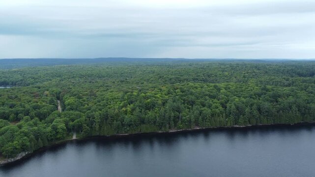 Aerial over the expansive wilderness of crown land located in the Tory Hill area of Highlands East, in southern Ontario, Canada. Flying north from Buckskin Lake towards east of Monrock Lake.